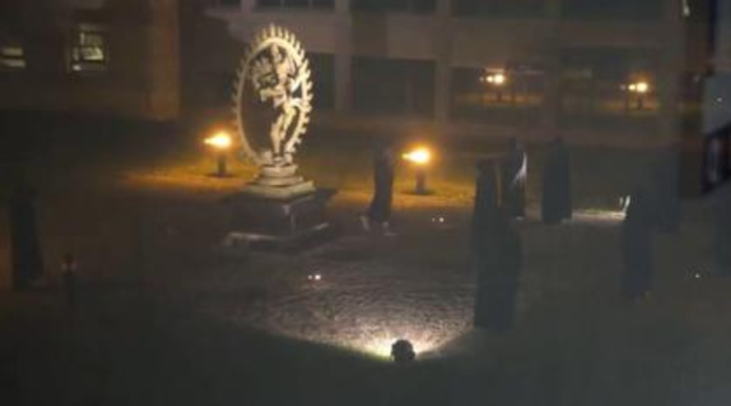 zakapturzone postacie wokół pomnika Shiva
